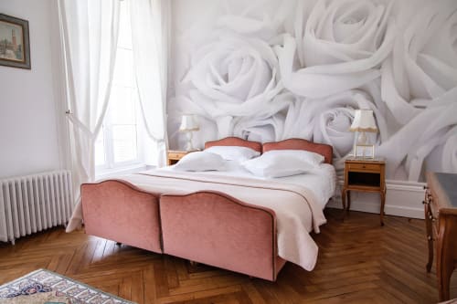 Chambre élégante du Château Du Landin avec lit corail, papier peint roses blanches, mobilier en bois et vue sur le lac