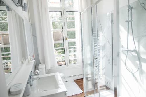 Salle de bains moderne et lumineuse à la Chambre Rose du Château Du Landin B&B, avec douche vitrée, lavabo blanc et vue sur le lac