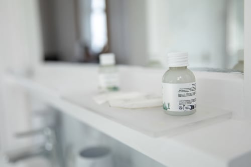 Flacon de gel transparent sur le comptoir blanc de la salle de bain du Château Du Landin B&B, LE LANDIN