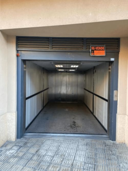 Empty garage with blue frame door and metal walls at Algemesi Home apartment, Spain