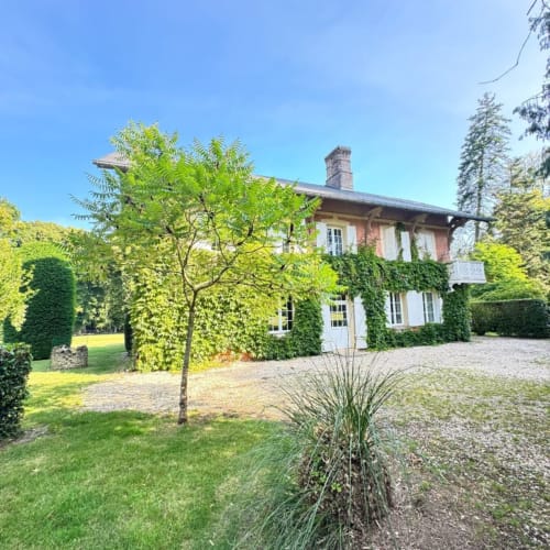 Villa Maison des Amis au Château Du Landin avec façade en brique, murs couverts de lierre, jardins aménagés et allée en gravier à Le