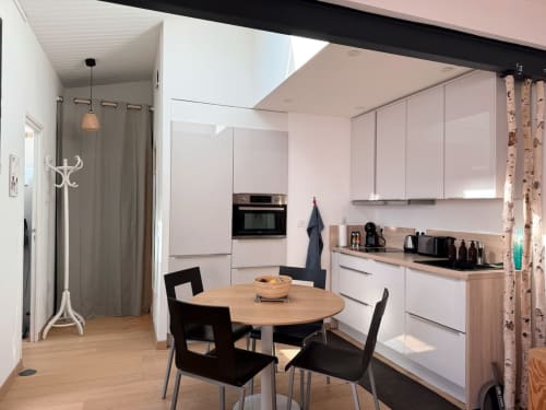 Cuisine et salle à manger modernes à la villa La Maréchale, Maison ARLOÉ, La Rochelle, avec mobilier blanc et table en bois