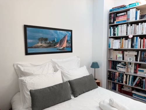 Chambre de la villa La Maréchale à Maison ARLOÉ, La Rochelle, avec lit, tableau de voilier, bibliothèques et vue sur la ville