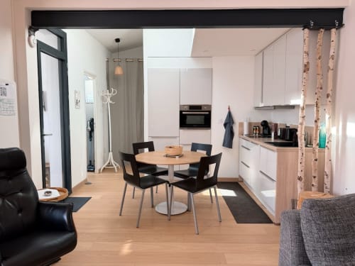 Cuisine et salle à manger modernes de la villa La Maréchale à Maison ARLOÉ, La Rochelle, avec table ronde et chaises noires