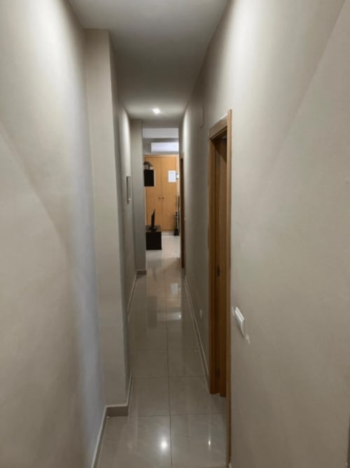 Bright hallway with white walls, wooden doors, and tiled flooring at Algemesi Home apartment in Spain