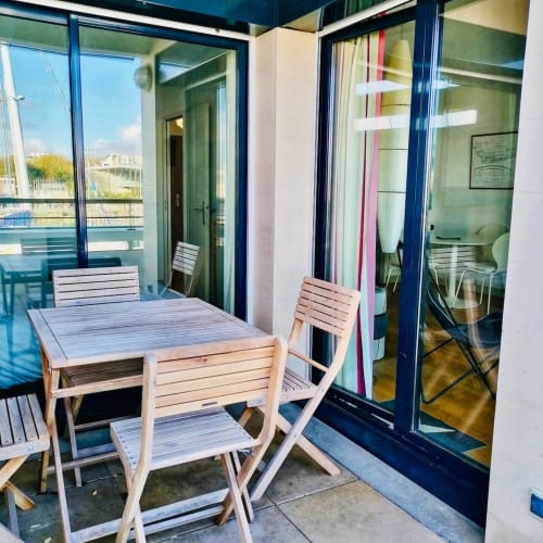 Terrasse avec mobilier en bois de l'appartement Le Chalutier à La Rochelle, donnant sur le bassin portuaire