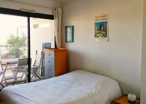 Chambre lumineuse avec literie blanche, balcon vue sur la rivière et mobilier en bois à l'Apartement Maison ARLOÉ La Rochelle