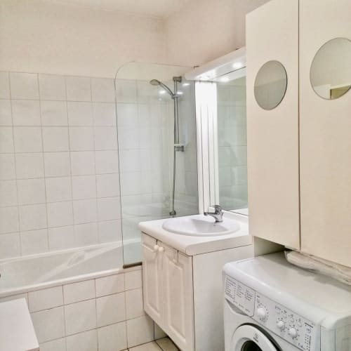 Salle de bains moderne à la Maison ARLOÉ à La Rochelle avec douche, lavabo, miroirs et machine à laver