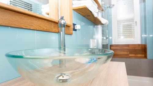 Modern glass vessel sink with chrome faucet in luxury bathroom at Versilia Panoramic Hotel, Como