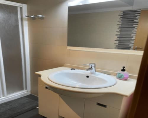 Modern bathroom with round sink, mirror, and shower in Algemesi Home apartment, Spain