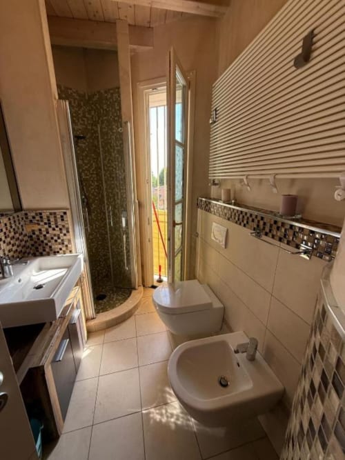 Modern bathroom at Versilia Panoramic Luxury in Tuscany, Italy, featuring shower, bidet, toilet, and vanity sink
