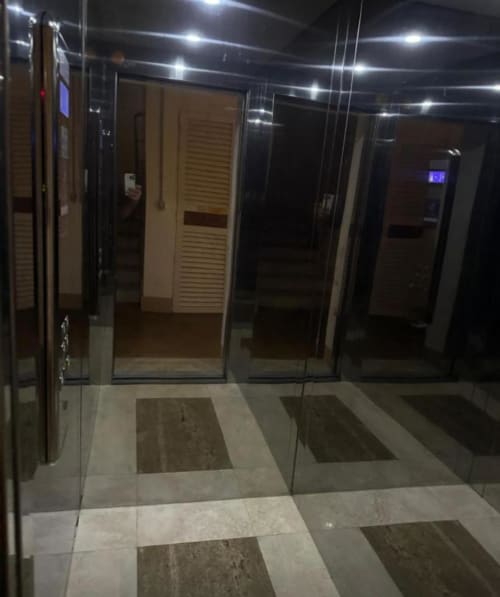 Modern hallway entrance at Versilia Panoramic Luxury, Como Italy, with glass doors and tiled floors