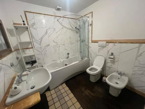 Modern bathroom in Sofy Penthouse at Versilia Panoramic Luxury, Como with marble tiles and glass shower enclosure