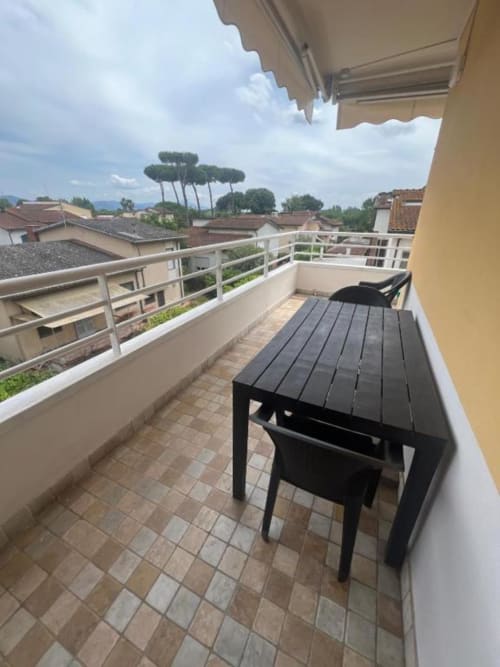 Sofy Penthouse terrace at Versilia Panoramic Luxury in Como, Italy, with dining table overlooking town and mountains