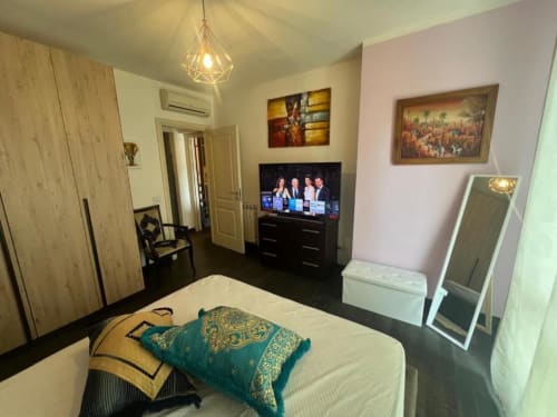 Sofy Penthouse bedroom at Versilia Panoramic Luxury Como with bed, TV, and geometric pendant light