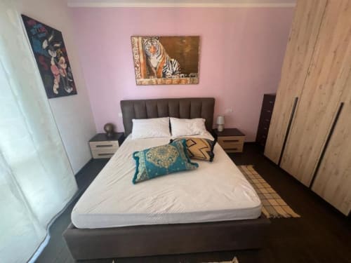 Sofy Penthouse bedroom at Versilia Panoramic Luxury in Como, Italy featuring pink walls, tiger artwork, and modern