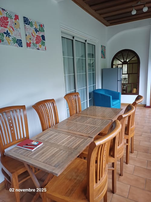 Salle à manger avec table et chaises en bois dans la chambre vue montagne Porte de Mafate, Salazie, Réunion