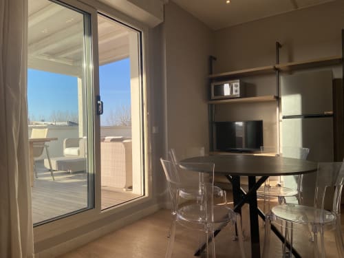 Modern penthouse apartment in Rimini with dining area, kitchenette, and panoramic balcony view