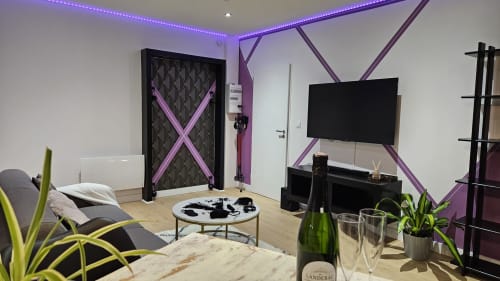 Suite Diamond moderne à la Résidence L'Hermitière avec éclairage violet, TV écran plat, jacuzzi, plantes et vin