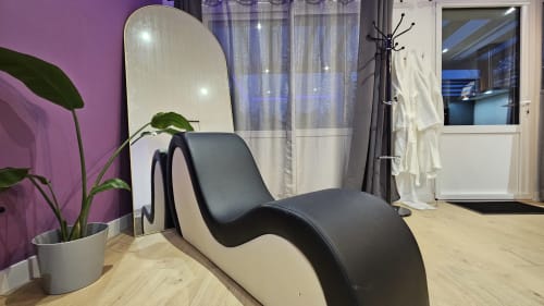 Élégant fauteuil lounge noir et blanc dans la Diamond'Suite à la Résidence L'Hermitière, avec mur d'accent violet et vue sur le jardin