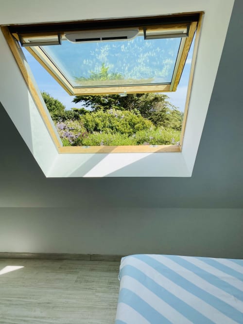 Vue panoramique du jardin luxuriant et des montagnes depuis la chambre de la Villa Métisse à Groix, France
