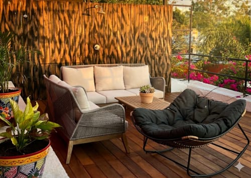 Modern balcony seating area at Villa Merida Boutique Hotel with cream sofa, black lounge chair, wooden table, tropical