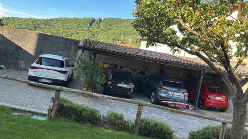 Parcheggio del B&B La Dolce Casa a Cremia con auto bianca esterna e più veicoli nel garage coperto