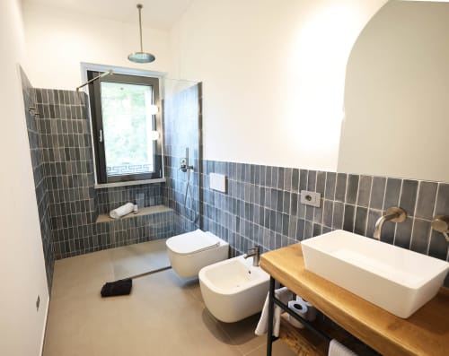 Modern bathroom at La Casa nel Bosco with walk-in shower, dual sinks, and garden views in Somma Lombardo