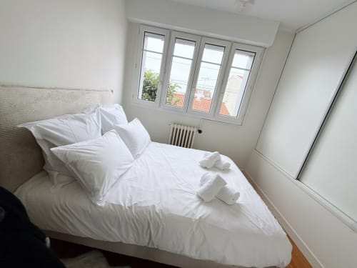 Chambre blanche épurée avec oreillers et serviettes pliées à la Villa Eleonore, La Rochelle