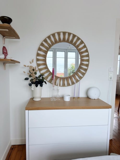 Entrée moderne avec commode blanche, plateau en bois, miroir rond décoratif à cadre de corde, vase blanc avec herbes de la pampa