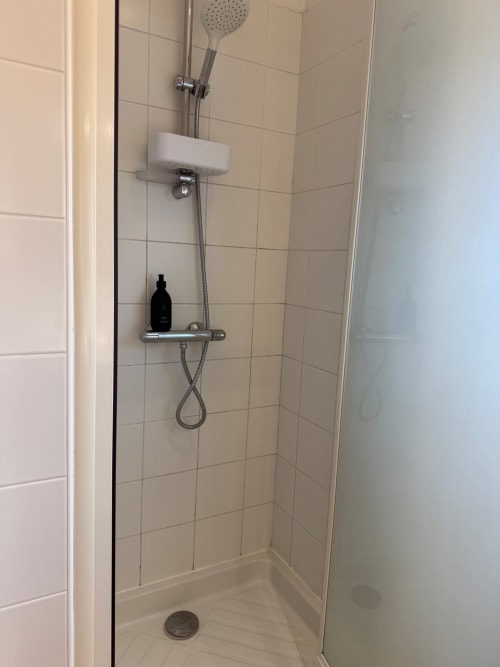 Salle de douche moderne à la Villa Eleonore de Maison ARLOÉ, équipée d'une pomme de douche pluie, tablette savon et carrelage