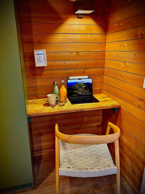 Holzlodge-Zimmer mit Arbeitsbereich, Schreibtisch, Laptop, Stuhl und Erfrischungen in Les Lodges de Vaugrigneuse