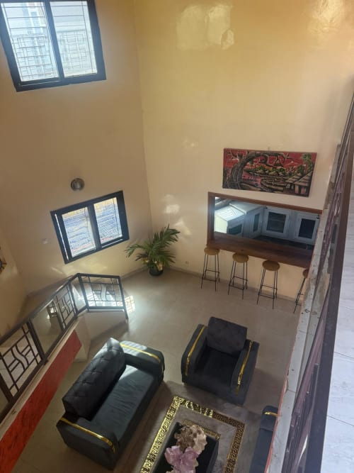 Vue aérienne de la chambre d'hôte Keur Medzo avec mobilier noir, fenêtres, plante en pot et murs décorés à Niaga