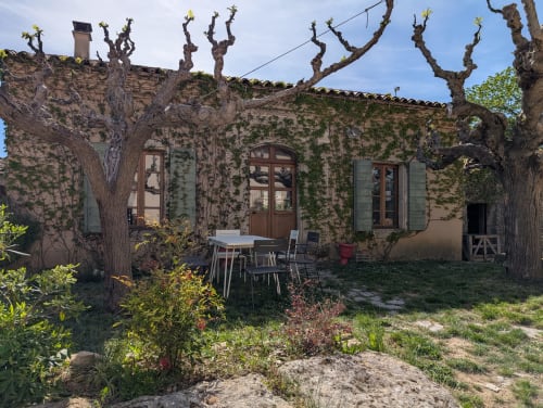 Charmante villa en pierre du Domaine de Pélican à Gignac, aux murs recouverts de lierre, platanes têtards et espace de repas extérieur