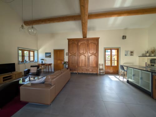 Spacious open-plan living area at Domaine de Pelican villa in Gignac with beamed ceilings, wooden wardrobe, terracotta tile