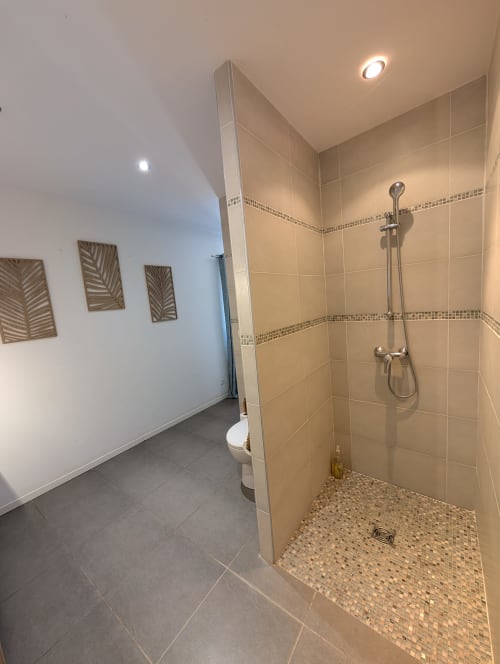 Modern bathroom with walk-in shower, beige tile, toilet, and recessed lighting at Domaine de Pelican villa in Gignac