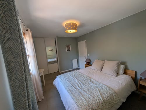 Bright bedroom at Domaine de Pelican villa in Gignac with queen bed, garden views, and modern ceiling light