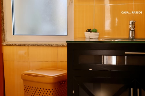 Banheiro moderno da Casa Dos Passos em Guarda com azulejos laranja, cuba preta contemporânea e plantas em vasos