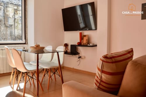 Sala de estar moderna em Casa Dos Passos, Guarda, com mesa de jantar, mobiliário confortável e TV na parede