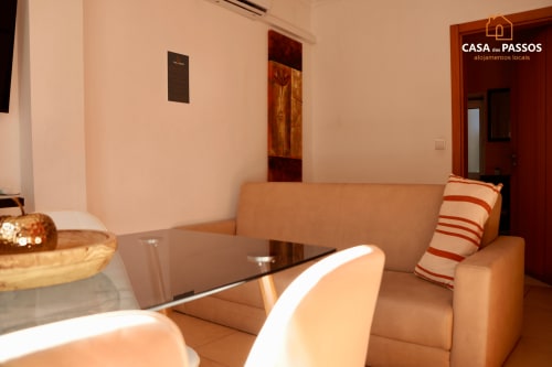 Sala de estar moderna da Casa Dos Passos em Guarda com sofá bege, mesa de vidro e decoração contemporânea