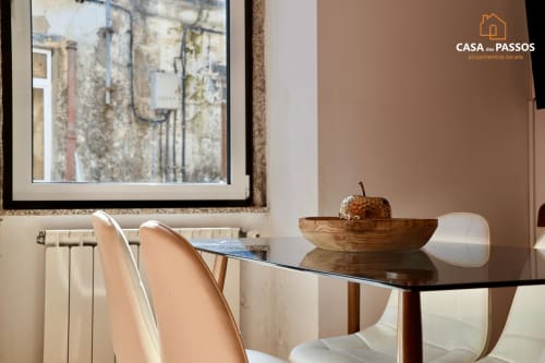 Sala de jantar moderna na Casa Dos Passos em Guarda com mesa de vidro, cadeiras brancas e vista da cidade