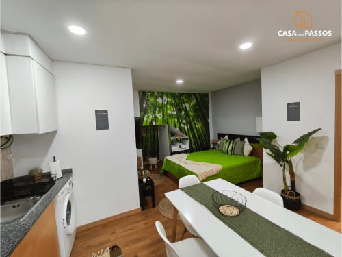 Estúdio moderno Casa Dos Passos em Guarda com kitchenette, cama verde, mesa de jantar e papel de parede com floresta de bambu