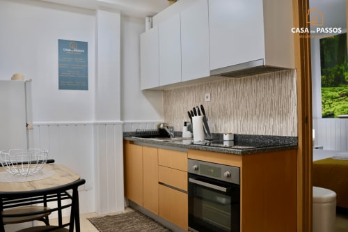 Cozinha moderna no apartamento Casa Dos Passos da SM Stays Collection, Guarda, com armários em madeira, bancada preta e branco