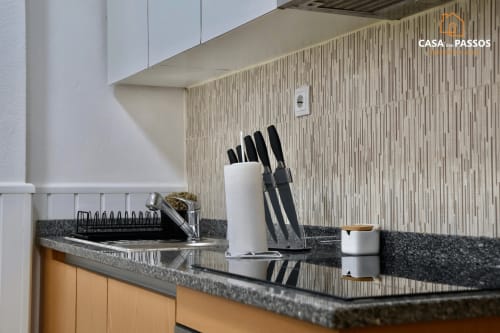 Bancada de cozinha moderna do apartamento Casa Dos Passos em Guarda com bloco de facas e acessórios