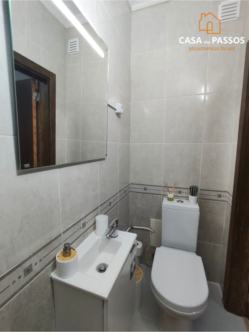Banheiro moderno no apartamento Casa dos Passos da SM Stays Collection, Guarda, com pia branca, sanitário e paredes revestidas