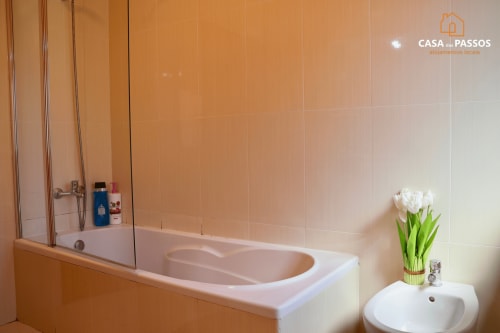 Casa de banho moderna com banheira e zona de duche com vidro no apartamento Casa Dos Passos, Guarda Portugal