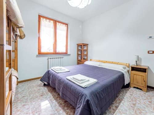 Bright bedroom at Como Holiday's Residenza Vecchio Faggeto apartment with double bed, wooden furniture, and mountain view