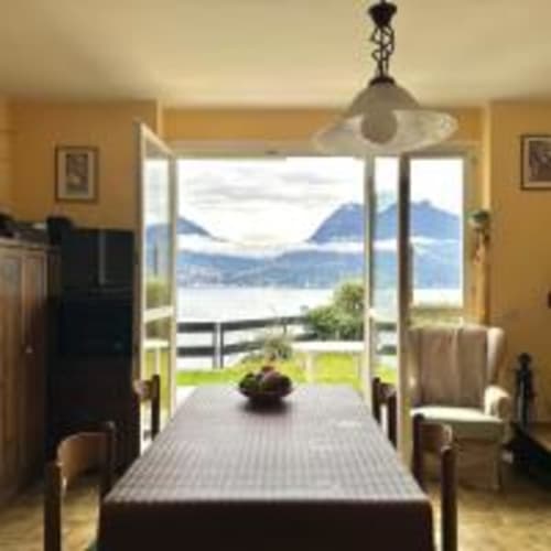 Camera da letto con vista sul lago presso l'appartamento Vecchio Molo di Como Holiday, con letto a quattro colonne e terrazza con vista sulle montagne