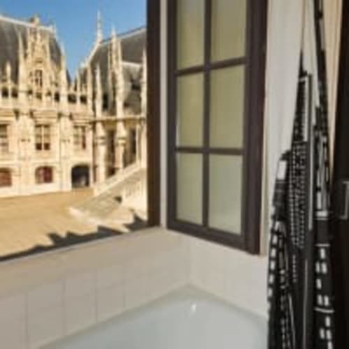 French hotel room balcony view overlooking Rouen Cathedral with ornate stonework, Hôtel les Initiés