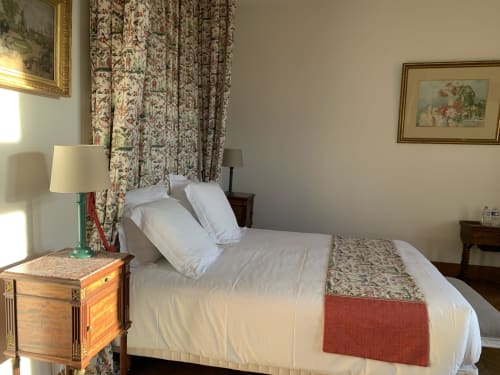 Chambre élégante à L'Abeaupinière avec draps blancs, rideaux fleuris et mobilier d'époque à Reboursin, France